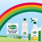 Produits Biovie représentés dans l'herbe avec un arc-en-ciel au-dessus et une maison dans les arbres en arrière-plan