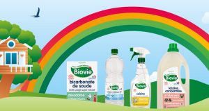 Produits Biovie représentés dans l'herbe avec un arc-en-ciel au-dessus et une maison dans les arbres en arrière-plan